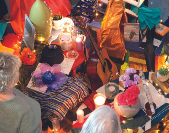 A group of people stand round objects that forms an artwork on the floor.