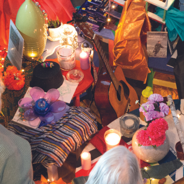 A group of people stand round objects that forms an artwork on the floor.
