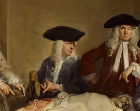 A group of surgeons gather round a dissection table.