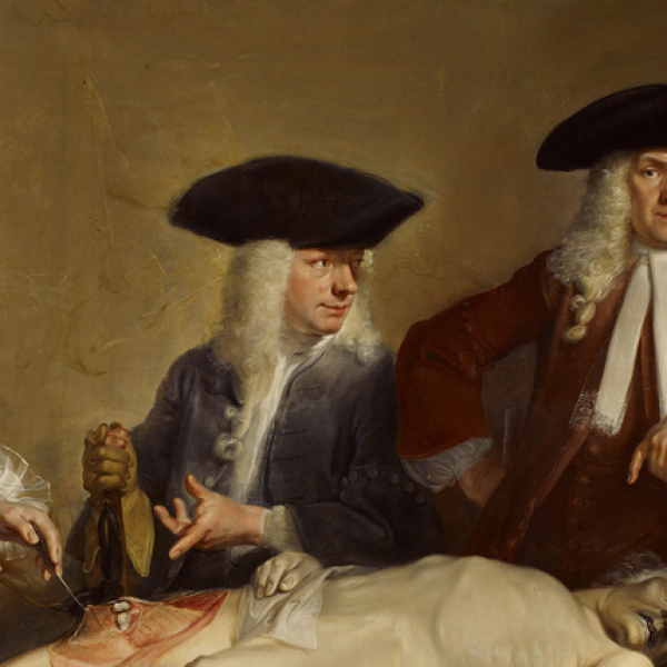 A group of surgeons gather round a dissection table.