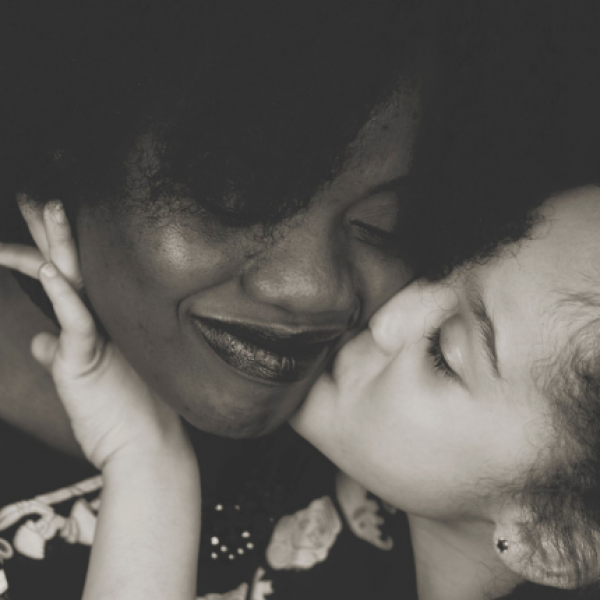 Girl kisses mother on cheek.