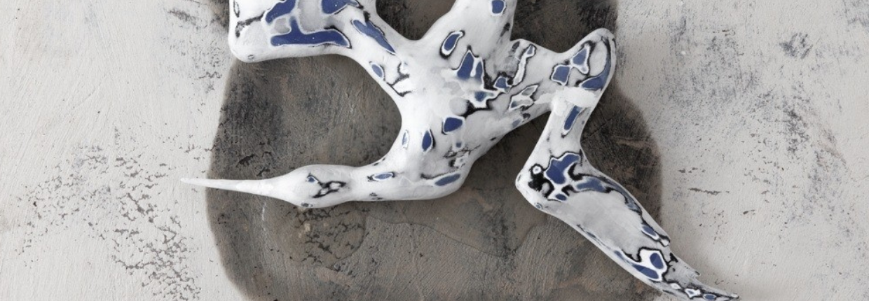 Ceramic bird lies on floor.
